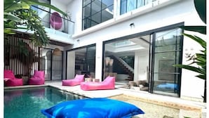 A modern house with a swimming pool, large windows, and a staircase leading to the upper floor. - Luxury Villa Devina I Seminyak I Pool, Yoga & Gym (kerobokan Kelod)