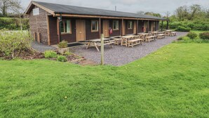A rustic wooden lodge with multiple cabins and a picnic area. - Oak (Cowbridge)
