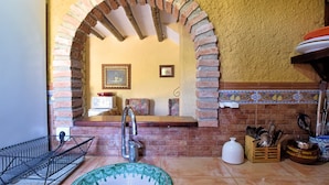 A kitchen with a brick archway, a sink, and various kitchen utensils. - Authentic cortijo with private pool (Loja)