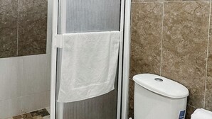 A bathroom with a toilet, a shower enclosure, and a tiled floor. - CASA VERANO SAN ANDRES (San Andrés)