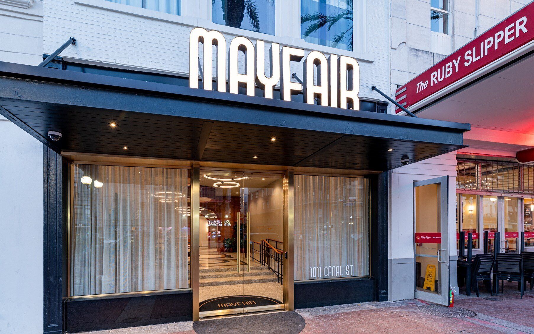 La façade de l’hôtel Mayfair, avec son entrée imposante et une enseigne indiquant « The Ruby Slipper ».