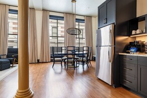 Una cocina moderna con un refrigerador de acero inoxidable, gabinetes oscuros y una cafetera.