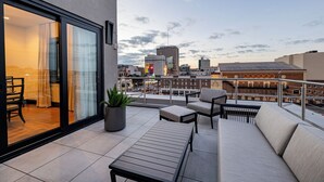 A modern outdoor seating area with a view of the city skyline. - The Mayfair (New Orleans)