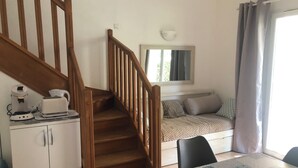 A bedroom with a bed, a window, a table, and a staircase. - House in a gated community with heated swimming pool (Mouries)