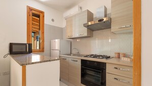 Una cocina moderna equipada con microondas, refrigerador, estufa, horno y armarios de madera.