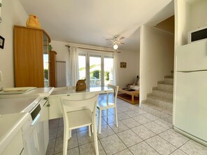 Eine Küche mit Essbereich, Deckenventilator und Blick ins Freie.