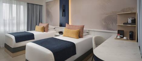 A hotel room with two beds, a desk, and a coffee machine.