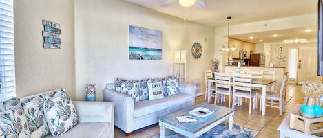 A living room with a sofa, coffee table, and a ceiling fan.