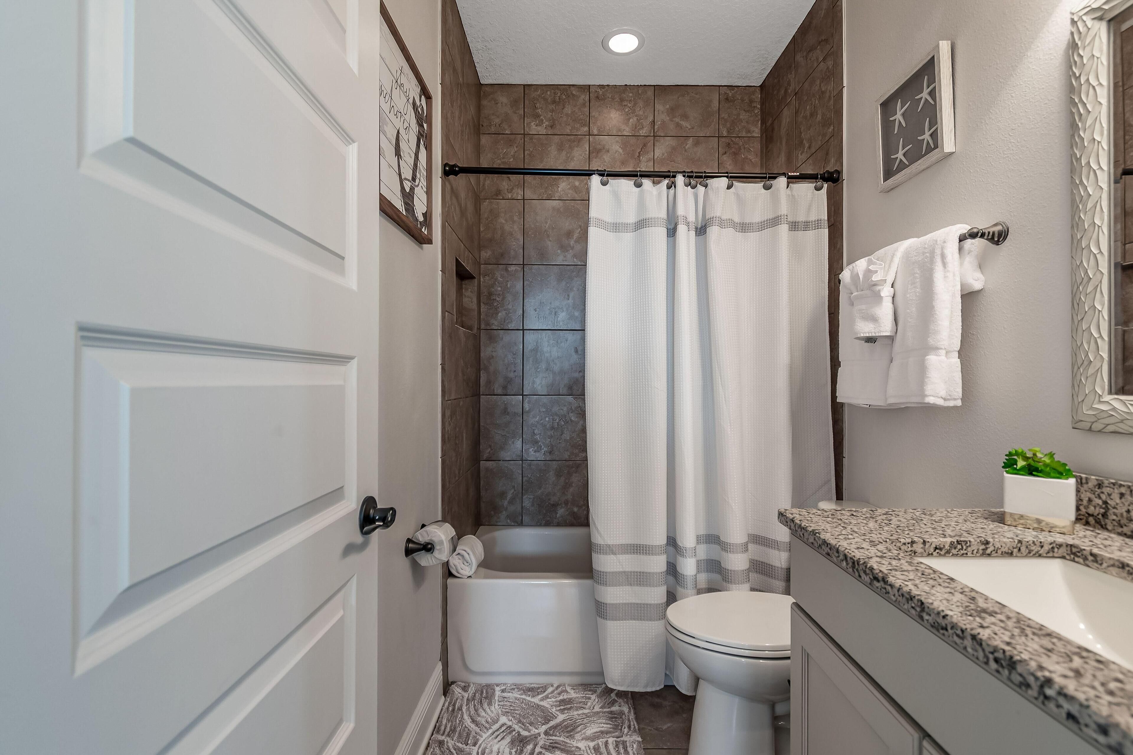 A bathroom with a bathtub, toilet, and sink.