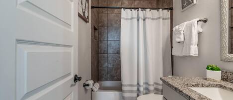 A bathroom with a bathtub, toilet, and sink.