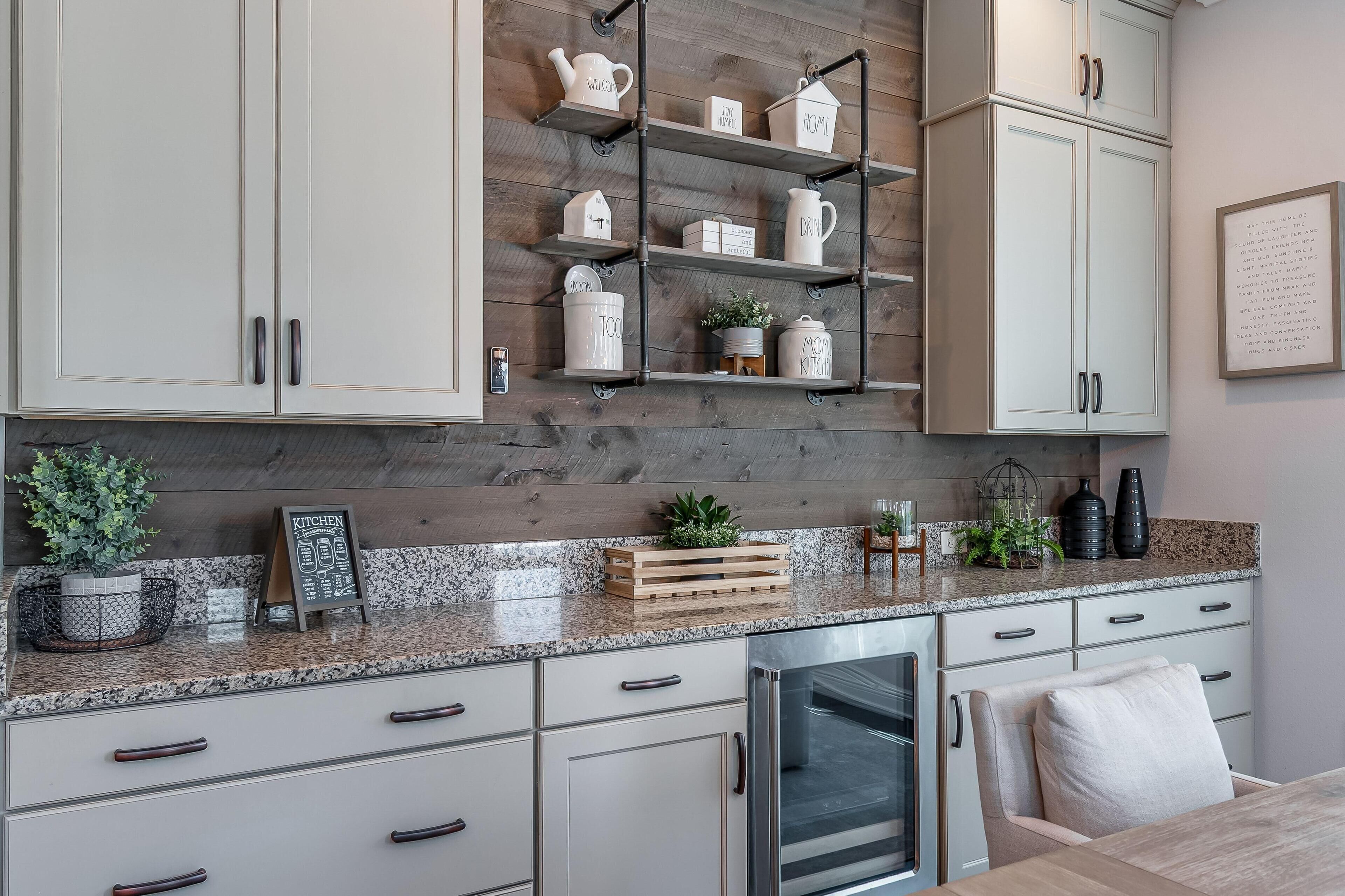 A modern kitchen with white cabinetry, a granite countertop, and a stainless steel oven.