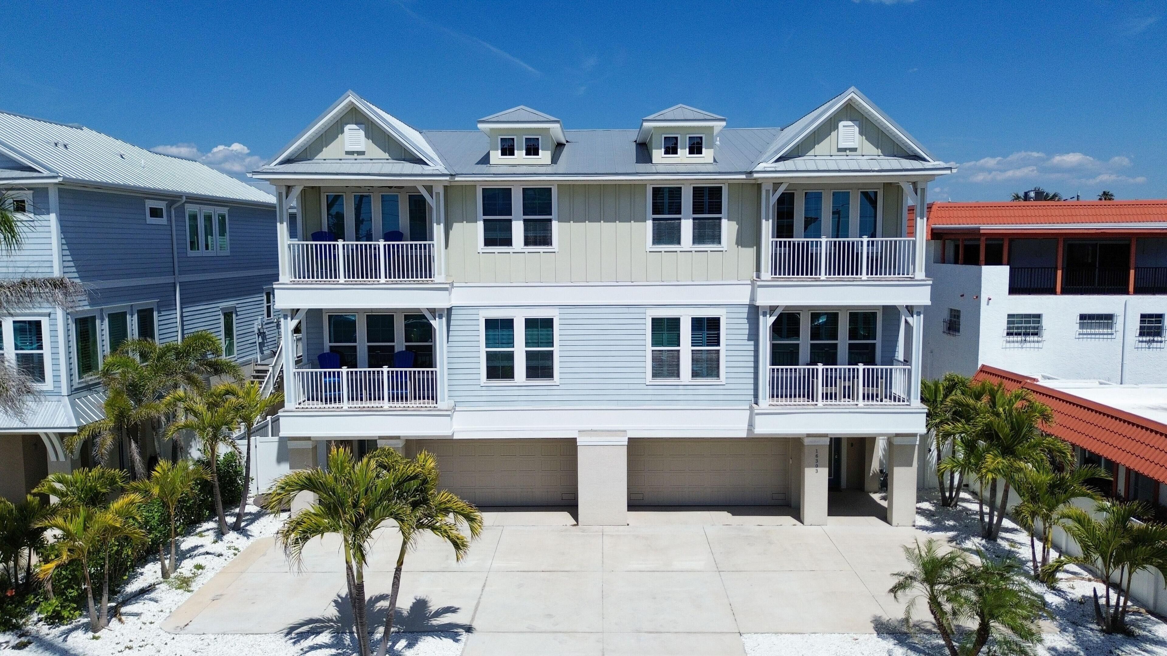 A multi-story residential building with balconies, a garage, and a driveway.