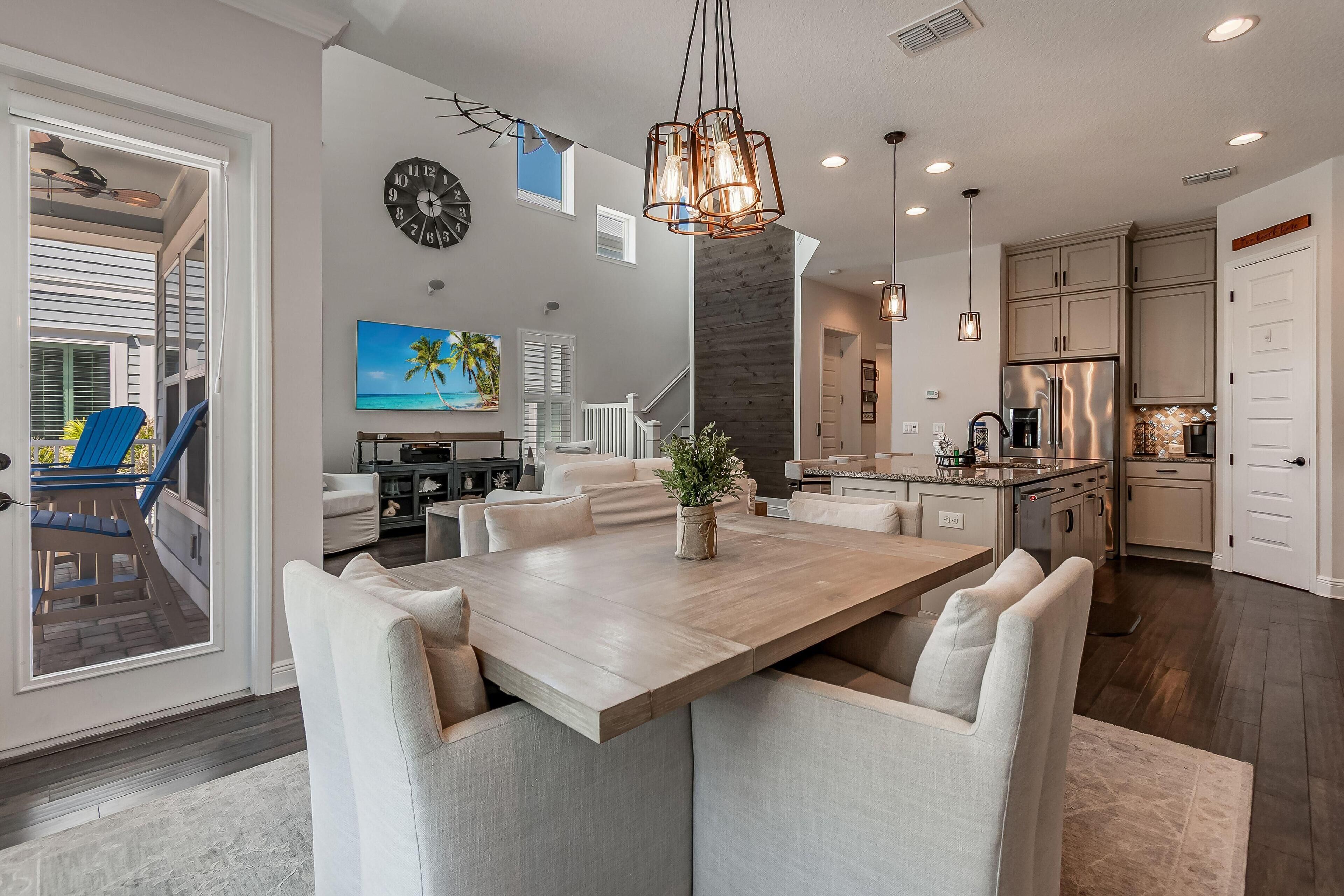 A spacious kitchen with a large island, modern appliances, and a dining area with a wooden table and cushioned chairs.