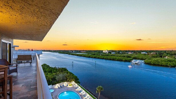 A balcony with a view of a river and sunset. - Bayshore Yacht & Tennis 806 (Indian Shores)