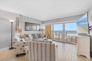 Relax in style with a comfortable sectional sofa and a stunning beach view from the balcony.