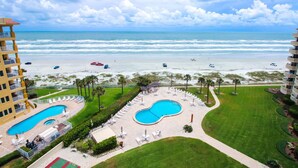 A hotel with a pool, beach view, and a golf course.
