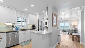 Una cocina moderna con armarios blancos, electrodomésticos de acero inoxidable y una isla grande.