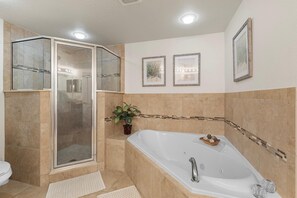 Ein Badezimmer mit einer Duschkabine, einer freistehenden Badewanne und einem Blumentopf.