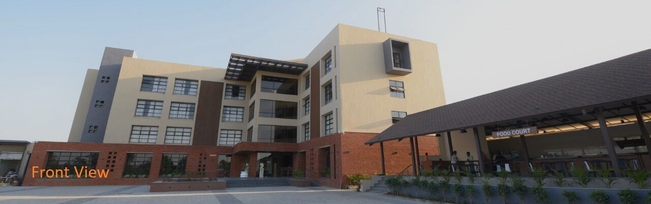 A multi-story building with a flat roof, a covered food court area, and a staircase leading to the entrance.