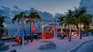 A beach with hammocks and a signboard. - Charming RV Hideaway campground in Key Largo; Sun & Fun! (Key Largo)