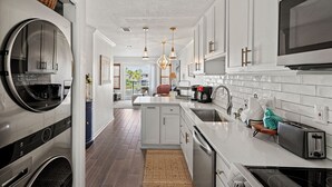 A modern kitchen with stainless steel appliances, a central island, and pendant lighting. - Coastal Paradise on Holiday Isle - Quiet place, snorkeling cove! Gated Parking! (Destin)