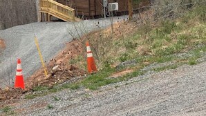 A small cabin with a green roof, a wooden deck, and a gravel driveway. - Glenville’s Rustic Charm (Glenville)