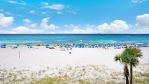 A beach with umbrellas and people. - Sunbird 309e (Panama City Beach)