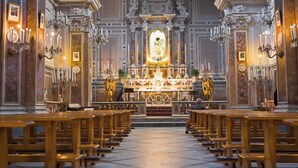 An ornate church interior with rows of wooden pews, a central altar, and statues. - B&B PALAZZO CROGHAN (Torremaggiore)