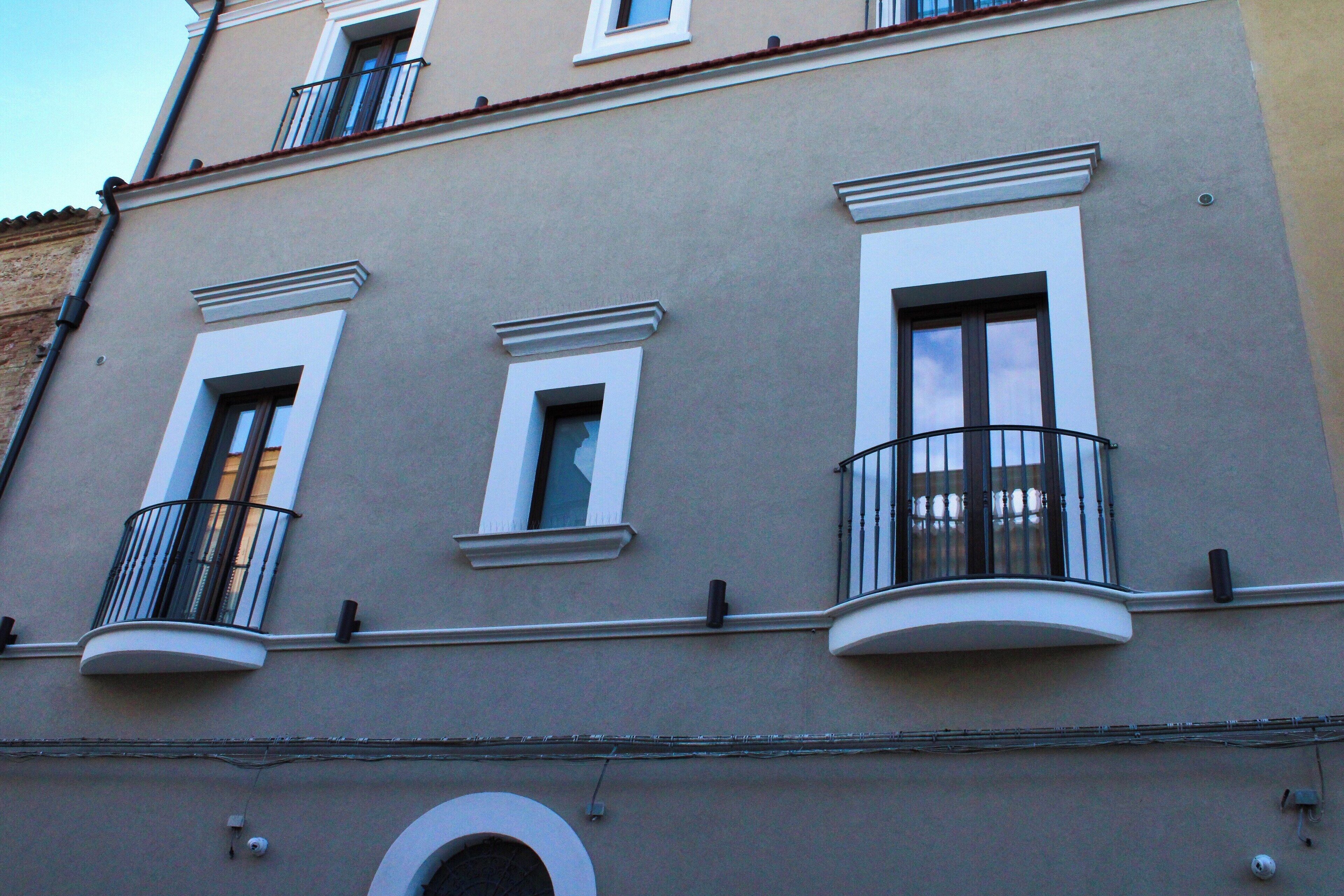 A building with three windows, each with a balcony.