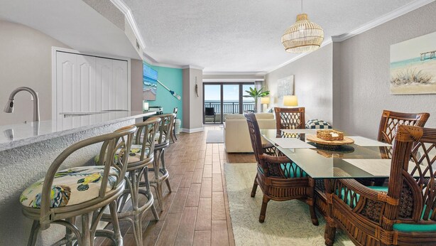 Una cocina amplia con una isla grande, sillas de madera y una mesa de comedor con candelabro.
