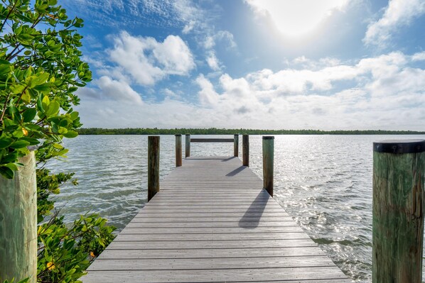 A wooden pier extending into calm water with a clear sky above. - Lazy Lobster (Fort Myers Beach)