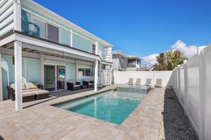 A modern house with a swimming pool, outdoor seating, and a covered patio area. - Lazy Lobster (Fort Myers Beach)