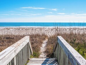 A wooden boardwalk leading to a beach with a clear view of the ocean. - 703 By The Sea by Topsail Realty (Holly Ridge)