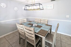 Enjoy meals in this dining area with a table for four, a pendant light fixture, and comfortable wooden chairs.