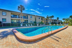 Relax by the pool surrounded by comfortable lounge chairs and umbrellas.