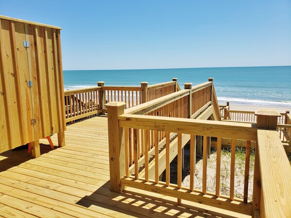 Relax on the deck overlooking the beach, where a cabin offers a table and seating area.