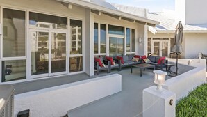 Un patio exterior moderno con zona de estar, ventanas amplias y un farol.