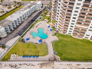 An aerial view of a hotel with a central pool, multiple balconies, and a parking area. - Sherwin Condominium 1801 (Daytona Beach Shores)