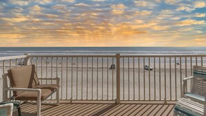A balcony with a view of the beach, a white railing, and two wicker chairs. - Ponce de Leon Towers 301 (New Smyrna Beach)