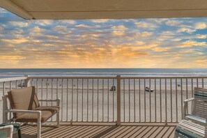 A balcony with a view of the beach, a white railing, and two wicker chairs. - Ponce de Leon Towers 301 (New Smyrna Beach)