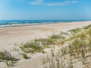 Enjoy a serene beach experience with gentle waves and a sandy shore.