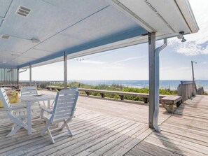 Relax on the deck with ocean views, featuring a comfortable seating area with a table.