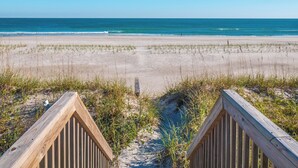 A wooden boardwalk leading to a beach with a clear view of the ocean. - Blue Crab by Topsail Realty (Holly Ridge)