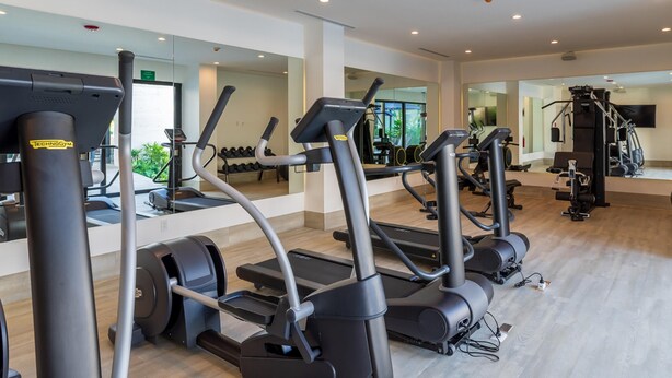 A gym with treadmills, ellipticals, and weight machines. - Ocd35- Luxury Condo With Ocean View (Playa del Carmen)