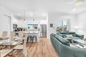 A modern kitchen with white cabinets, stainless steel appliances, and a central island.