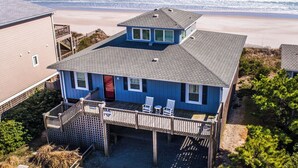 Uma casa de dois andares com varanda com vista para a praia.