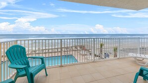 A balcony with a view of the beach, a pool, and lounge chairs. - Aruba 206 (Daytona Beach Shores)