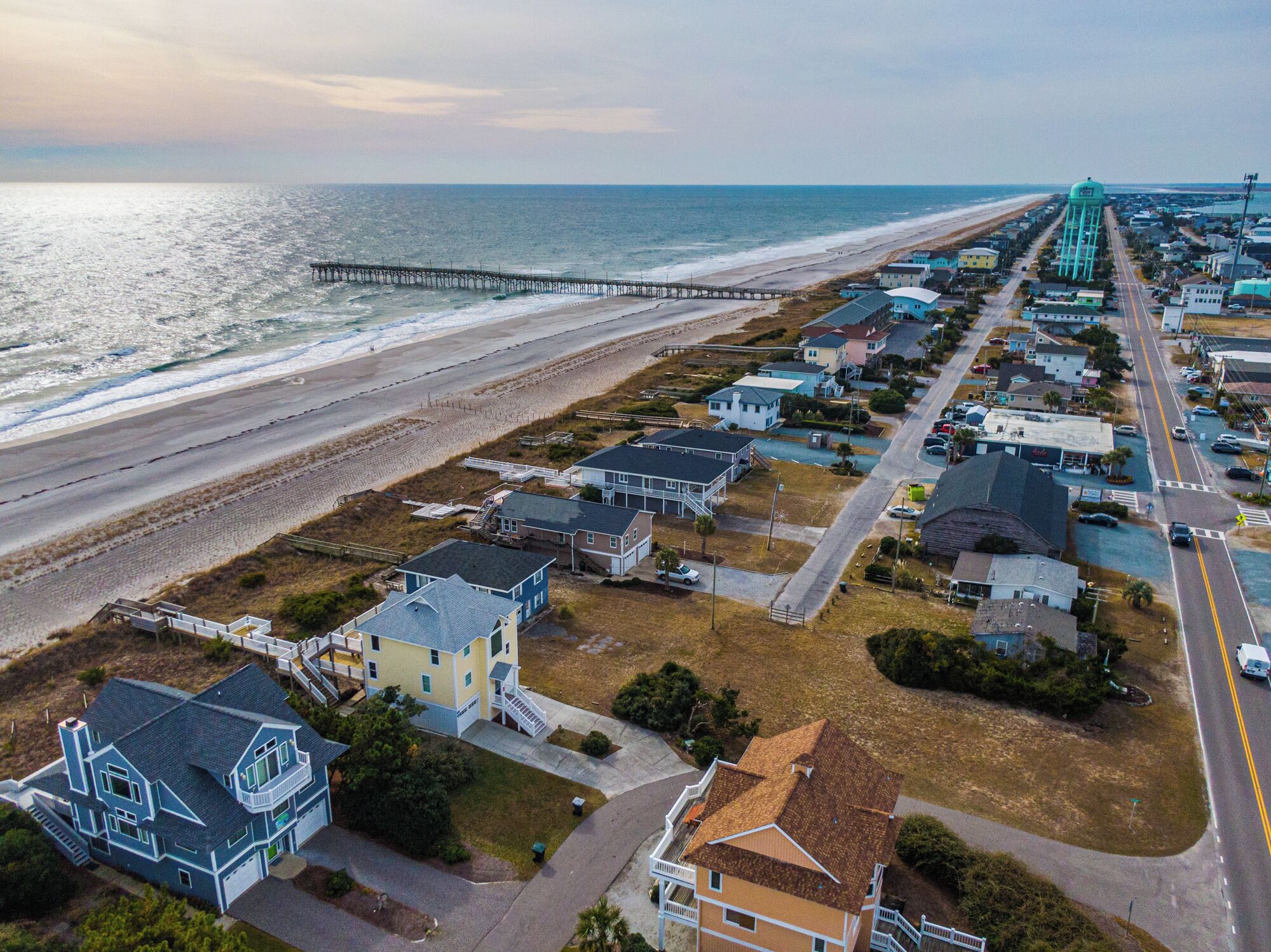Une zone résidentielle côtière comprenant des maisons, une plage et une jetée.