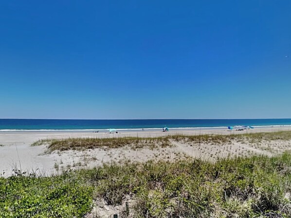 Enjoy the serene beach scene with a clear sky and calm sea.