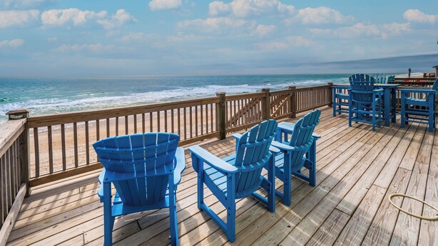 A wooden deck with blue chairs and a table overlooking the ocean. - Bel Sole (Beautiful Sun) by Topsail Realty (Holly Ridge)